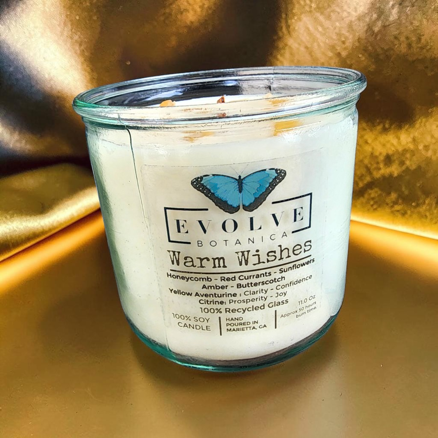 Evolve Botanica Rocks Candle Warm Wishes with a wood wick, featuring citrine and aventurine gemstones in a soy candle setting.
