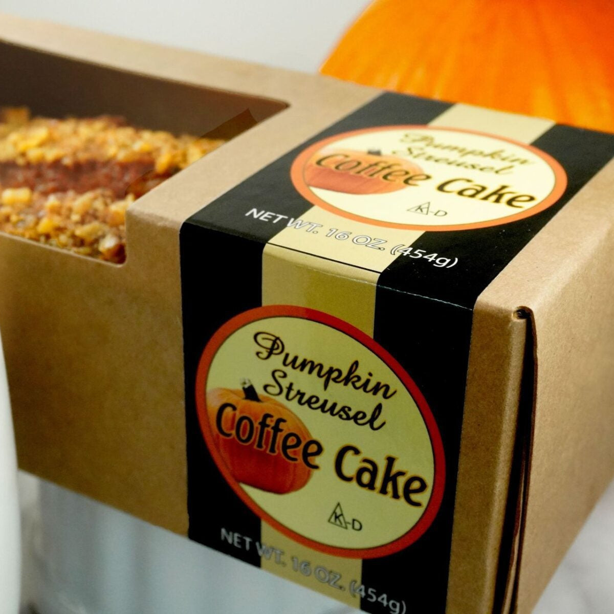Slice of Pumpkin Streusel Coffee Cake from Beatrice Bakery showing moist pumpkin cake with crunchy streusel topping, 16 oz size.