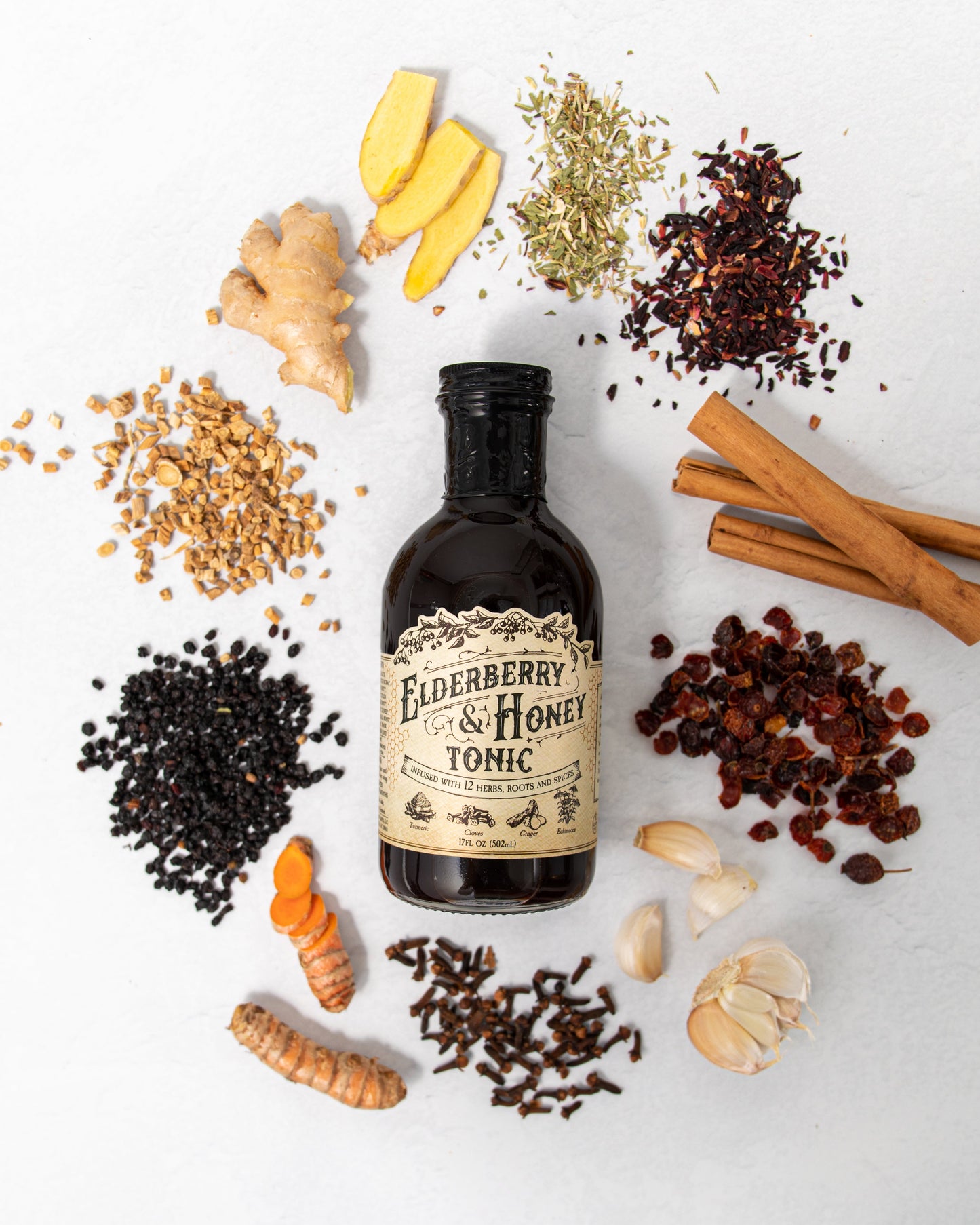 Elderberry and honey tonic bottle from Roots and Leaves LLC with fresh elderberries and honey in a glass container.