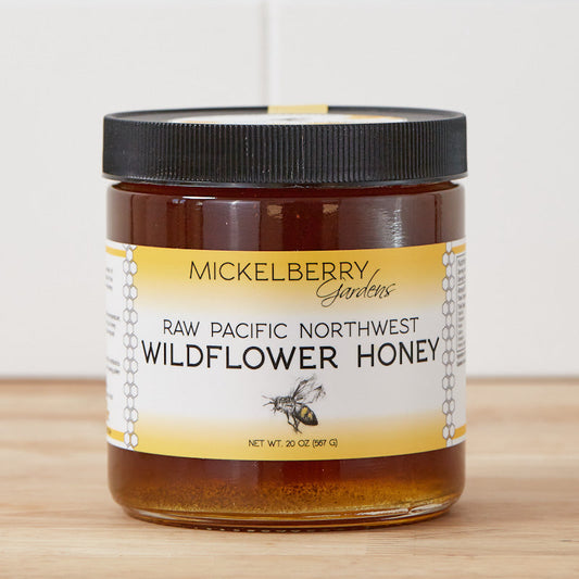 Raw Pacific Northwest honey by Mickelberry Gardens in a glass jar, showcasing golden honey from local beekeepers.