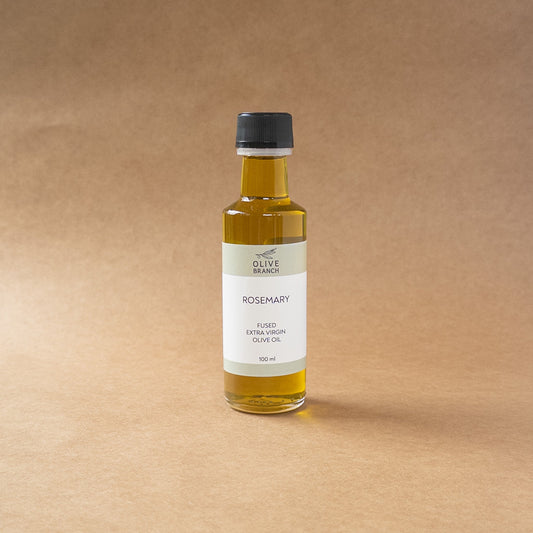 Bottle of Olive Branch Oil & Spice Rosemary Fused Extra Virgin Olive Oil with fresh rosemary sprigs and a rustic background