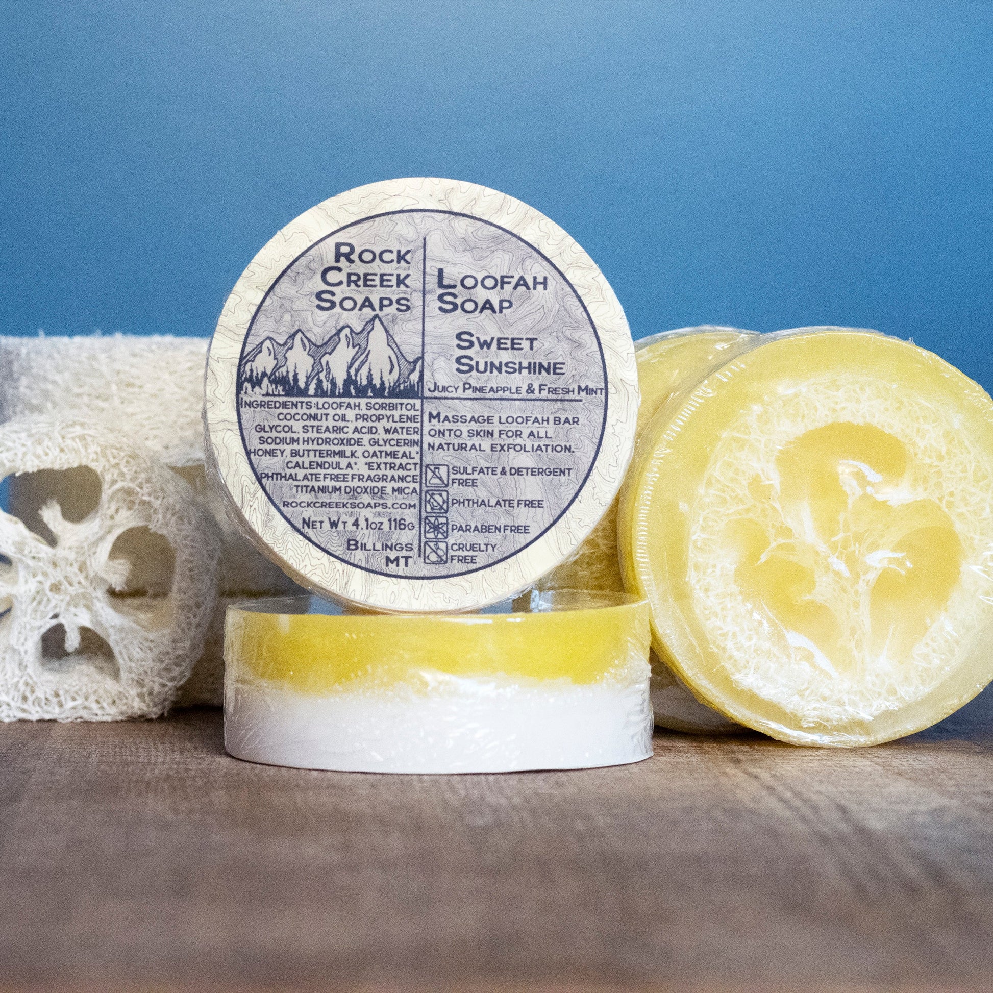 Natural loofah soap bar with sweet sunshine scent from Rock Creek Soaps, showing the soap's textured surface and vibrant packaging.
