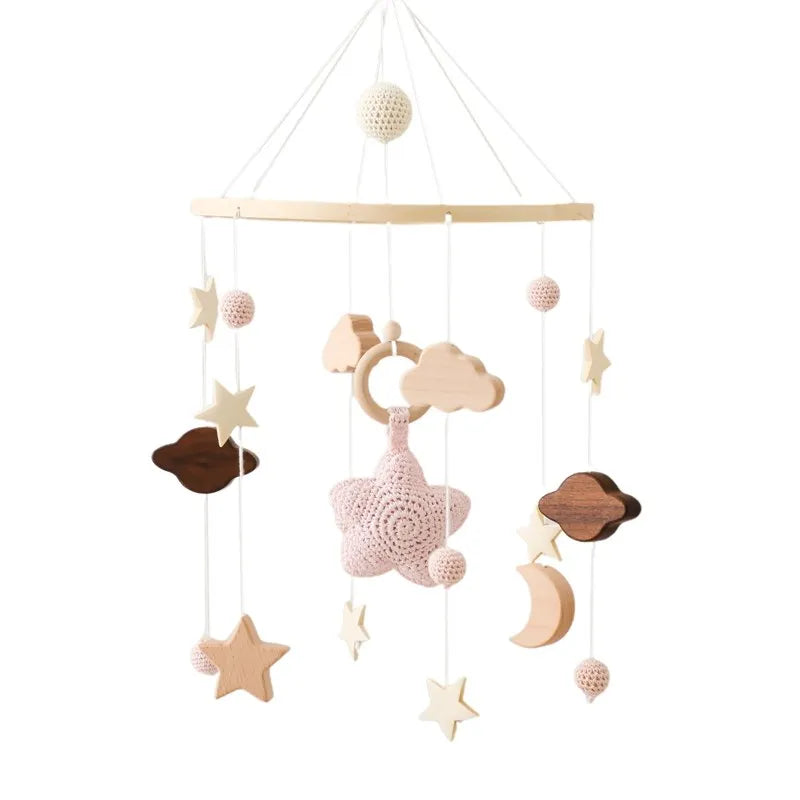 Wooden mobile hanging toys by Petite Pioneers with colorful animal figures and soft fabric accents for nursery decoration.