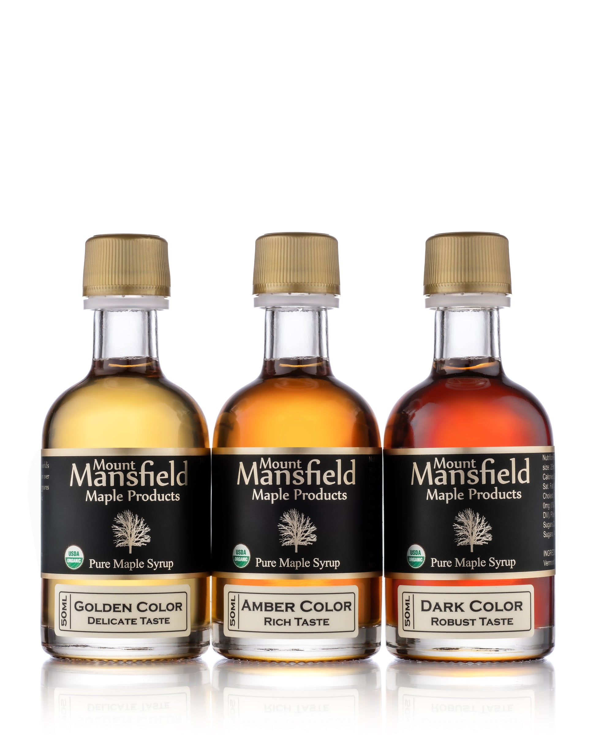 Assorted bottles of Mount Mansfield Maple Products organic pure Vermont maple syrup sampler in glass bottles.