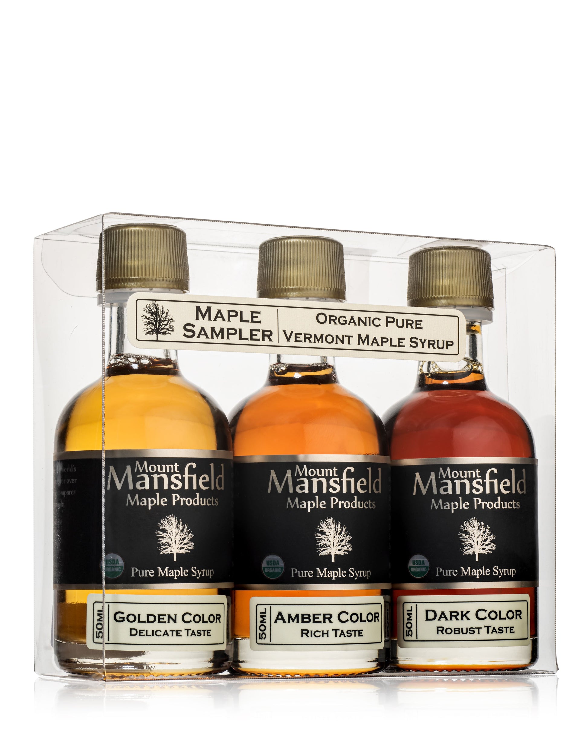 Assorted bottles of Mount Mansfield Maple Products organic pure Vermont maple syrup sampler in a wooden box.