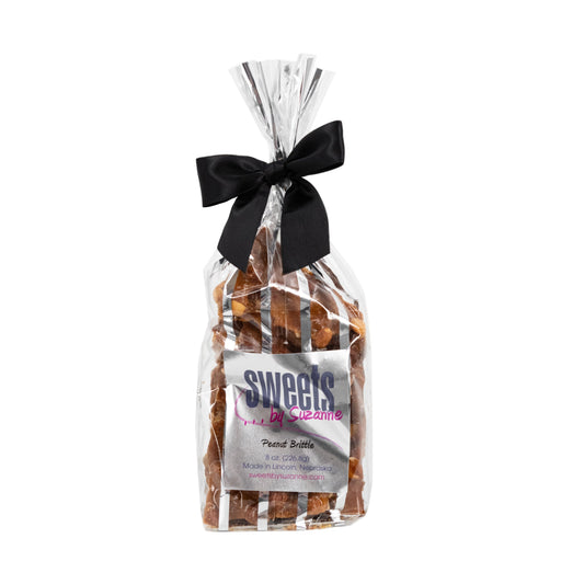 Homemade peanut brittle in an 8 oz package by Sweets by Suzanne, featuring golden caramelized peanuts and crunchy texture.