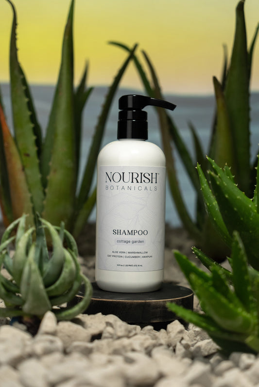 Rustic Strength Aloe Vera Shampoo from Cottage Garden, with a clear bottle and green aloe vera plant in a bathroom setting