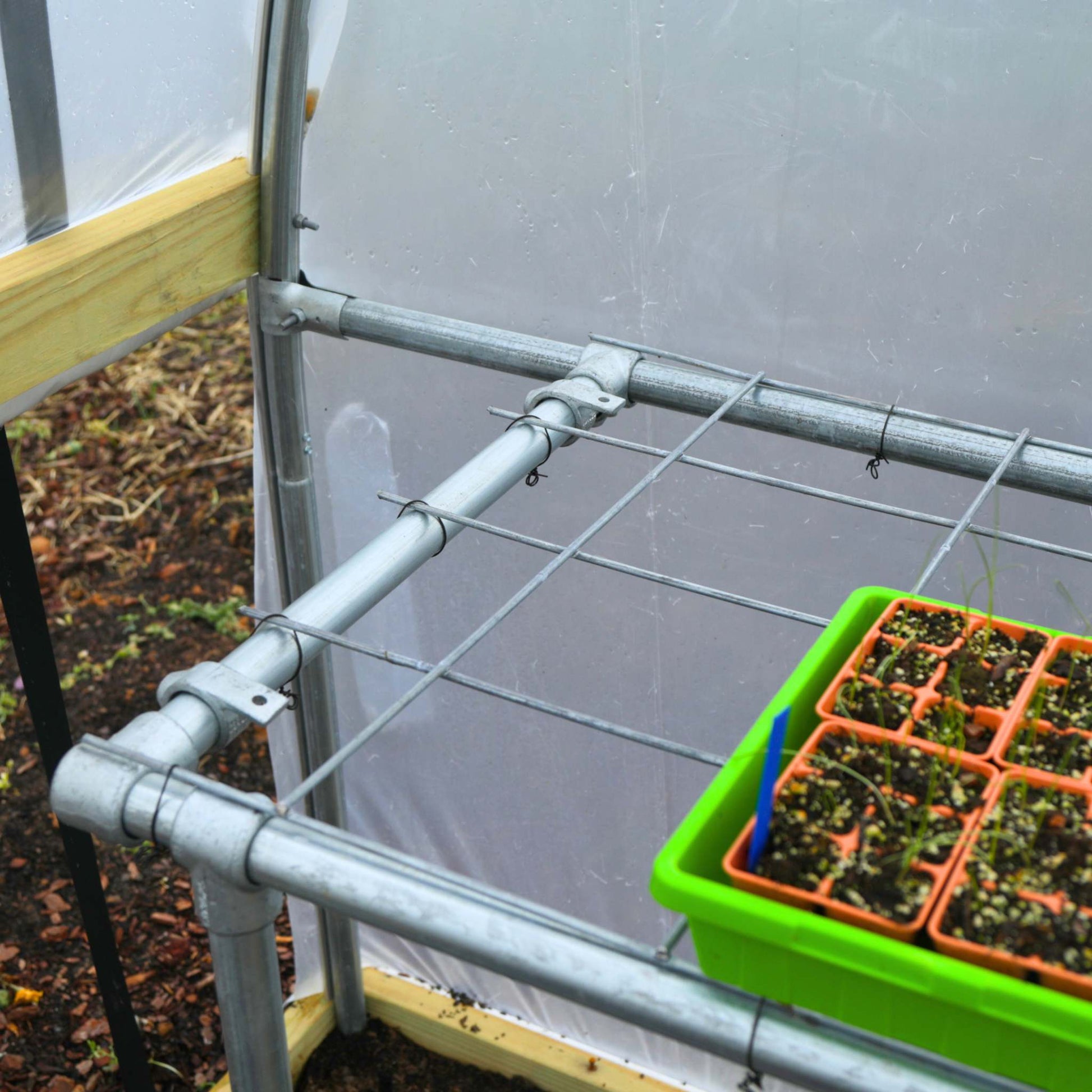 Side view of Bootstrap Farmer DIY foldable potting bench with work surface and storage shelves for gardening and planting tasks.