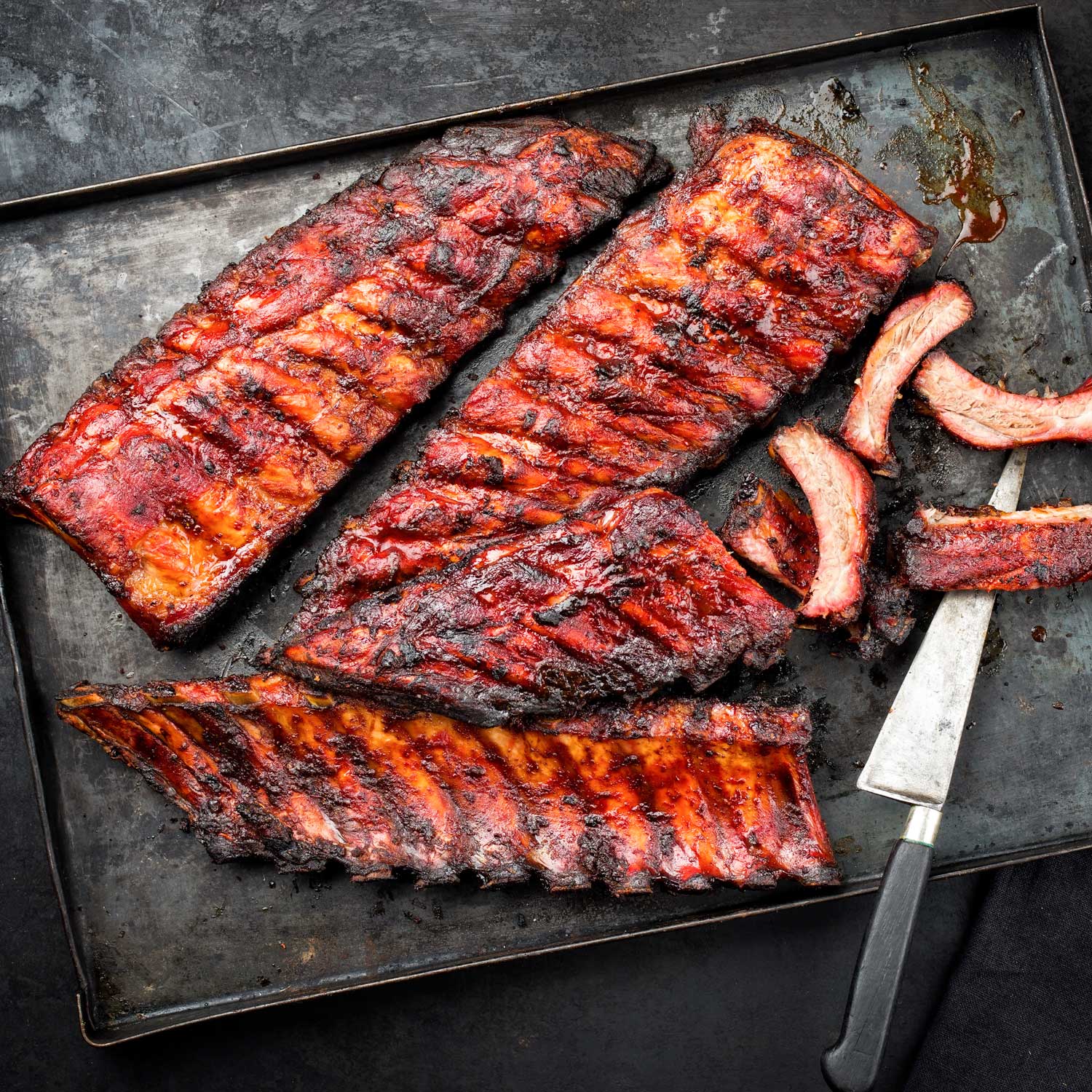 Smoked baby back ribs from Pig of the Month BBQ, part of a 3-rib sampler pack, ready for grilling or serving.