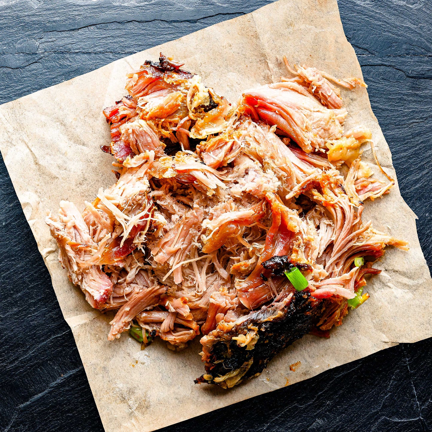 Smoked BBQ pulled chicken from Pig of the Month BBQ, showcasing tender, flavorful smoked meat ready for serving.
