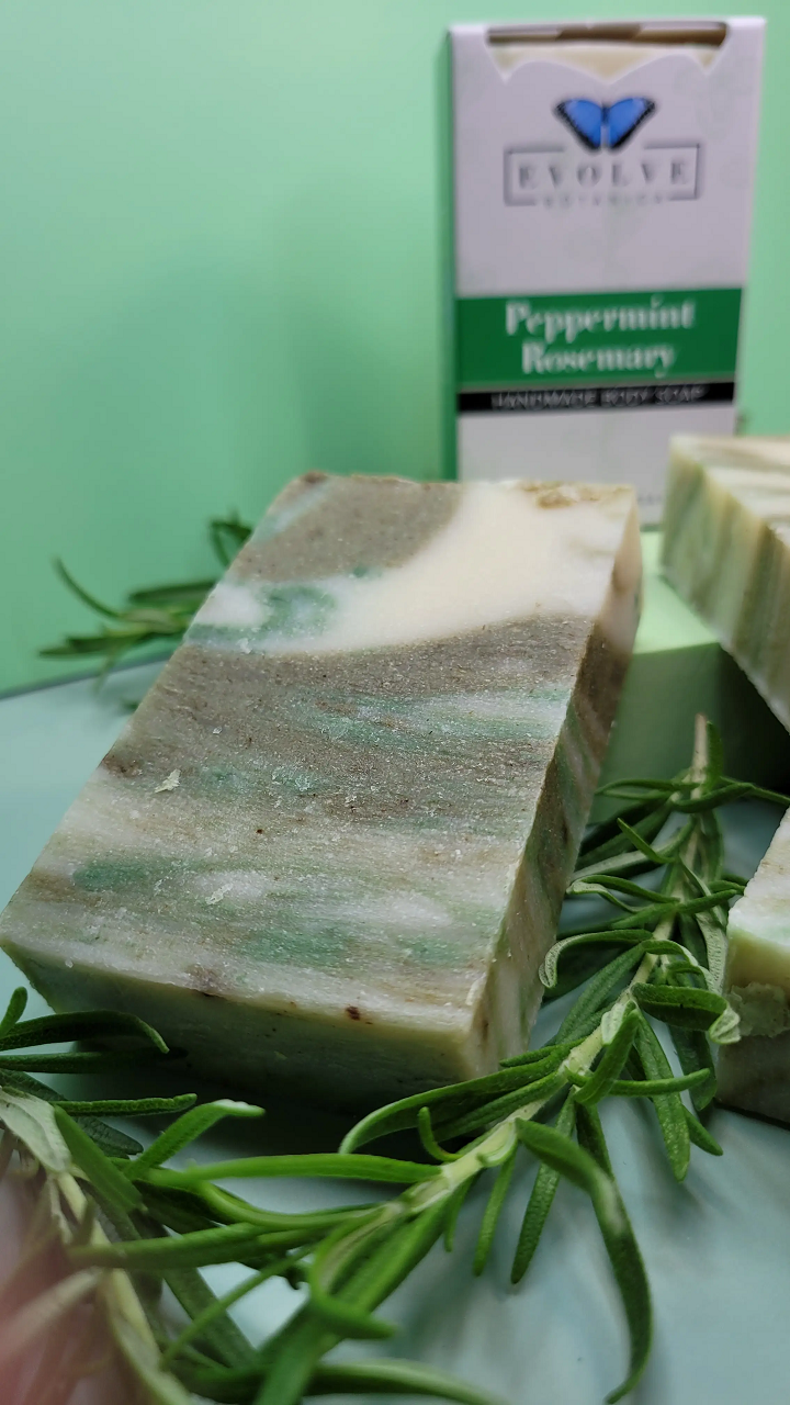 Evolve Botanica peppermint rosemary standard soap bar with fresh herbs and natural ingredients, showcasing the soap's texture and scent.