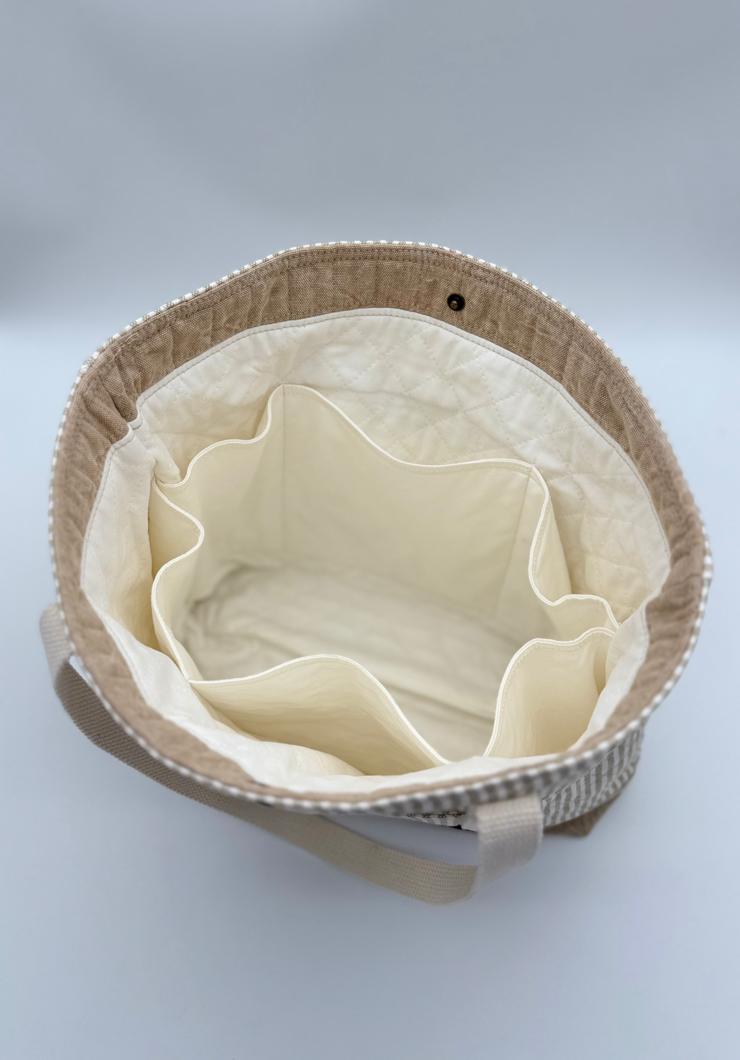 Interior view of taupe striped quilted canvas tote bag by C2 Creations LLC, showing spacious inside with snap closure.