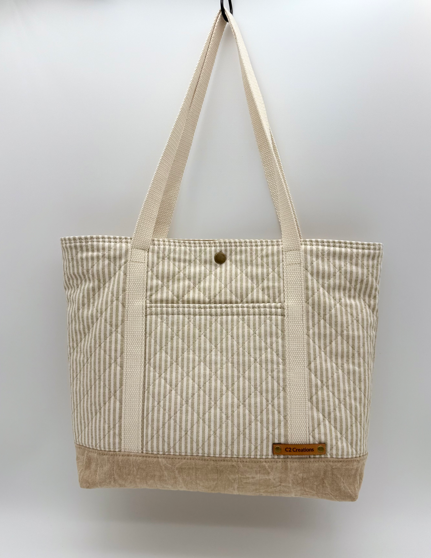 Taupe striped quilted canvas tote bag with snap closure, handmade by C2 Creations LLC, front view showing handles and stitching details.