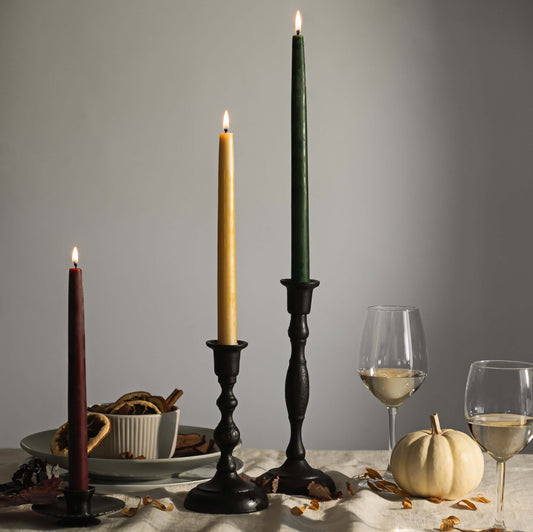 Handcrafted cast iron taper candle holders on a Thanksgiving table setting with tall tapers, featuring a rustic, artisanal design.