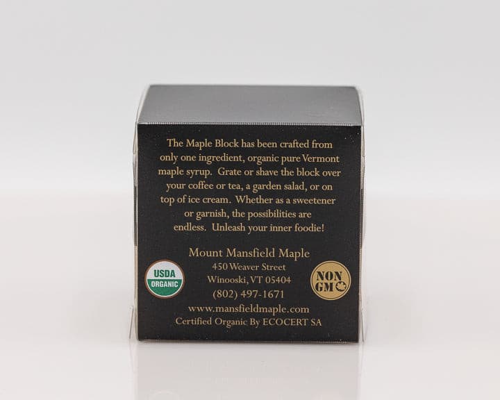 A close-up of Mount Mansfield Maple Products' Maple Block, showcasing rich, golden maple candy on a wooden surface.