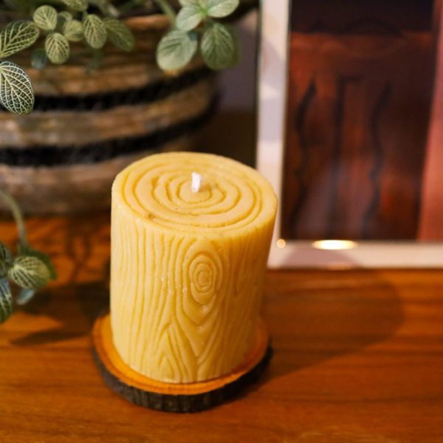 Beeswax candle with wooden base, 12 oz, from Buzz Savories, LLC, showcasing a warm, natural home decor piece.