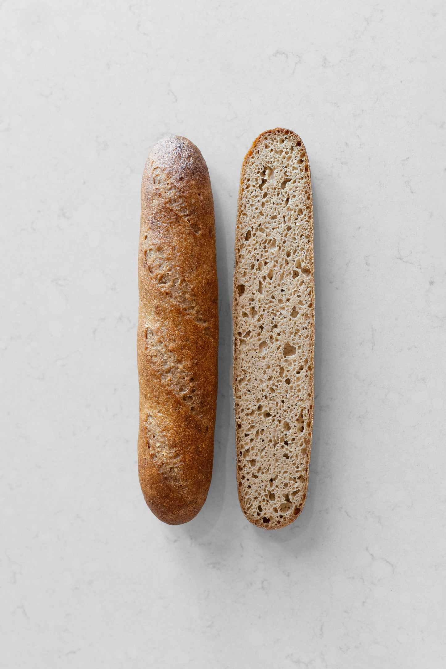 French gluten-free vegan sourdough baguette from Heaven Gluten Free Bakery, showing a golden, crusty baguette on a wooden surface.