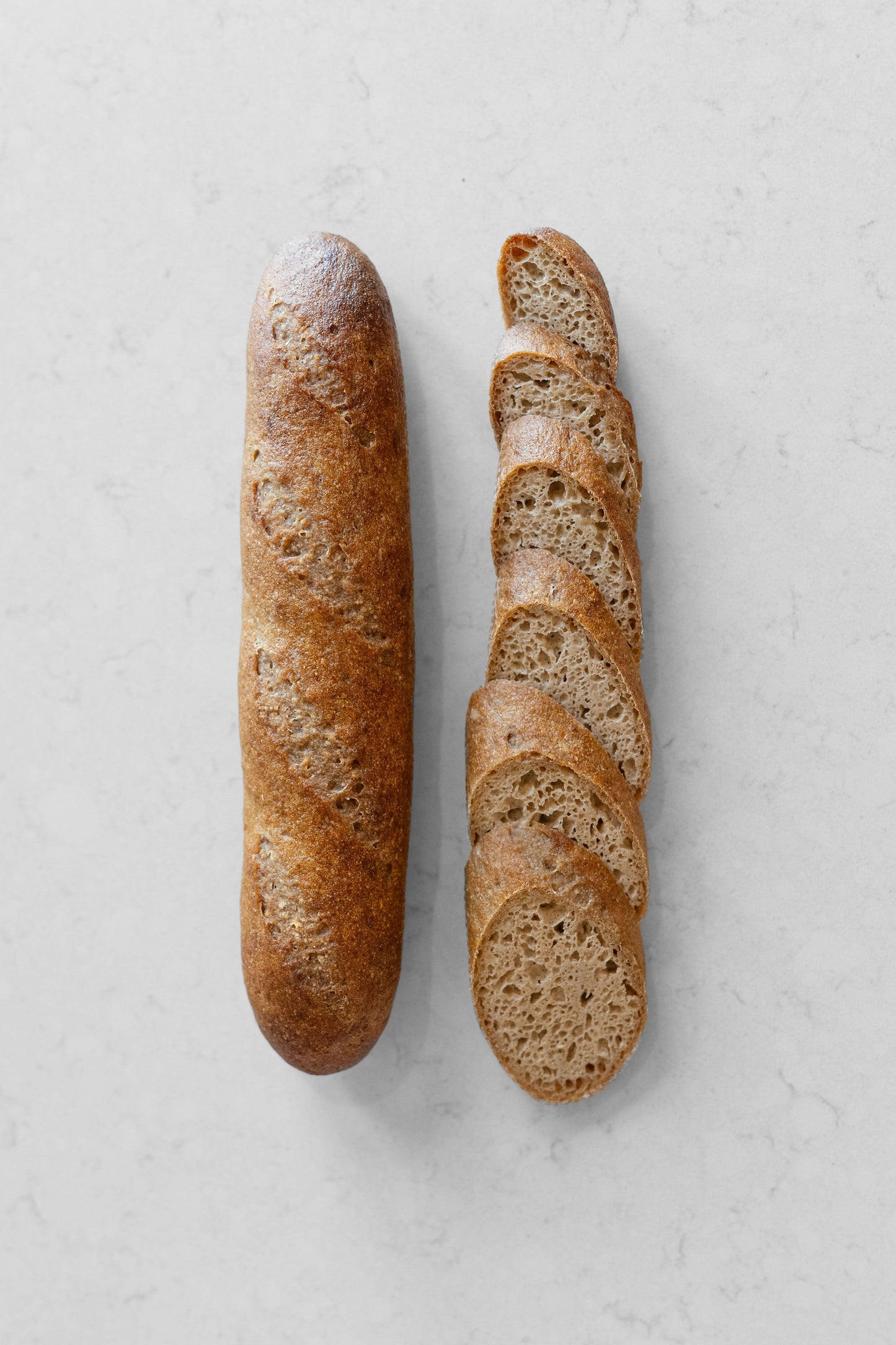 Fresh gluten-free vegan sourdough baguette from Heaven Gluten Free Bakery, showcasing a golden crust and rustic shape.