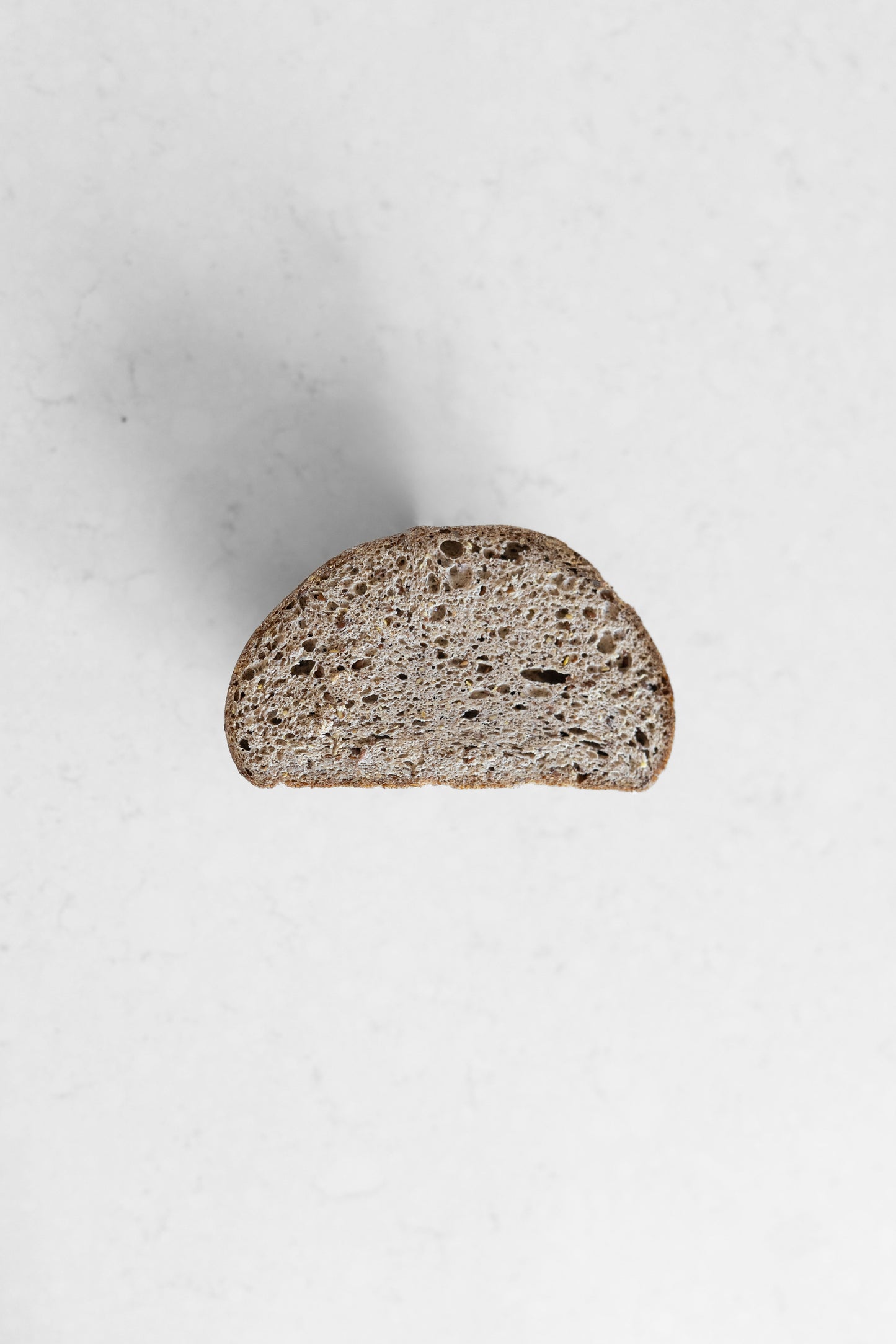 Dark flaxseed-allspice sourdough boule by Heaven Gluten Free Bakery, gluten-free vegan sourdough bread with seeds and spices.