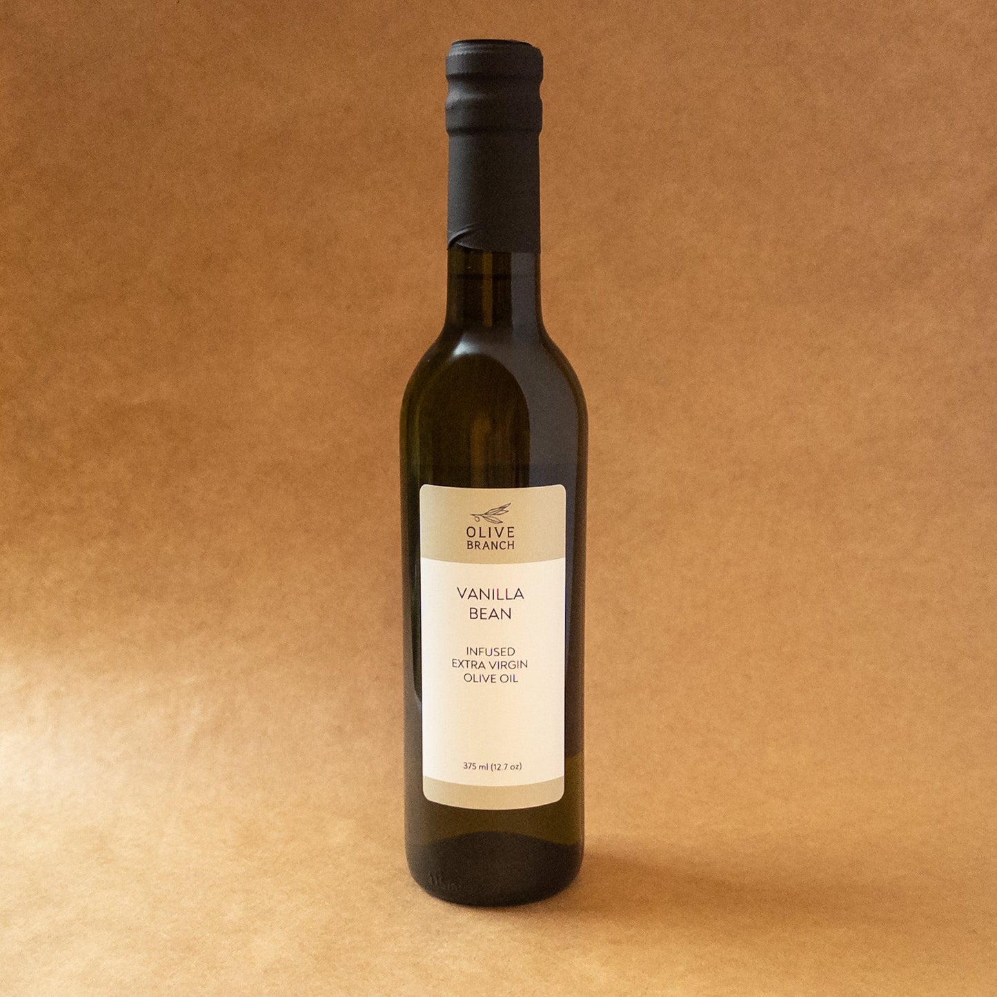 Bottle of Olive Branch Oil & Spice vanilla bean infused extra virgin olive oil with vanilla bean pieces inside, showcasing the infused flavor.