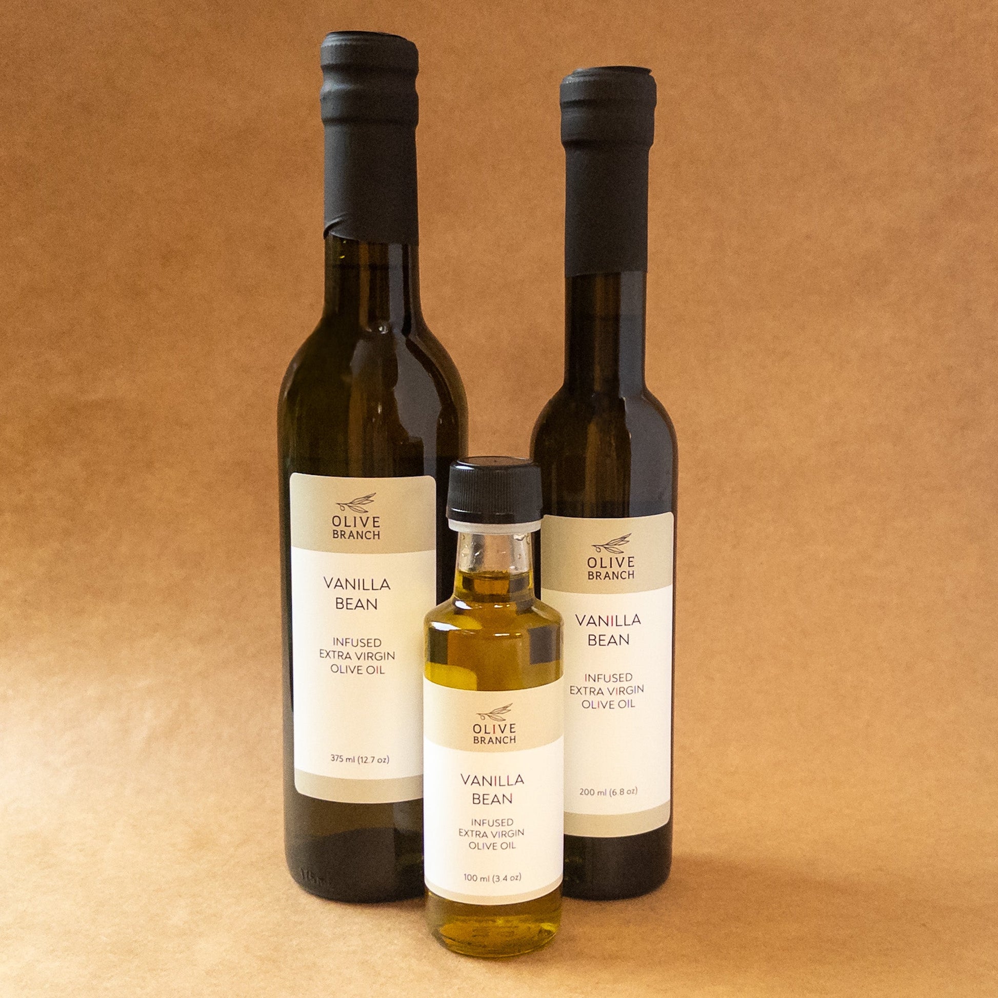 Bottle of Vanilla Bean Infused Extra Virgin Olive Oil from Olive Branch Oil & Spice, showing the clear glass bottle and vanilla bean infusion.