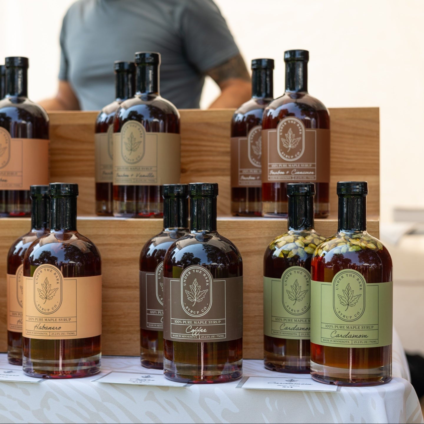 Glass jar of Under The Bark Syrup Co. Coffee Maple Syrup with a rich, dark amber color and a label featuring coffee beans.