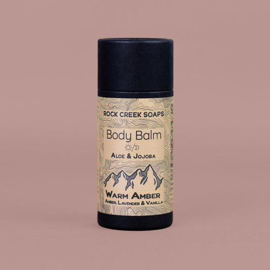 Warm amber body balm solid lotion bar by Rock Creek Soaps featuring black amber, vanilla, and French lavender scent.