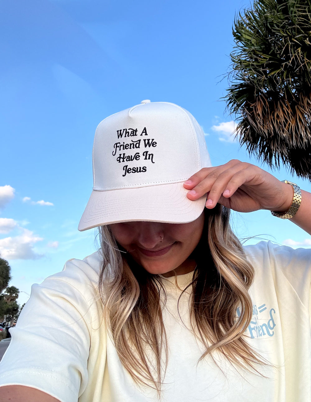 Elevated Faith trucker hat featuring "What a Friend in Jesus" embroidered design on the front, casual and stylish headwear.