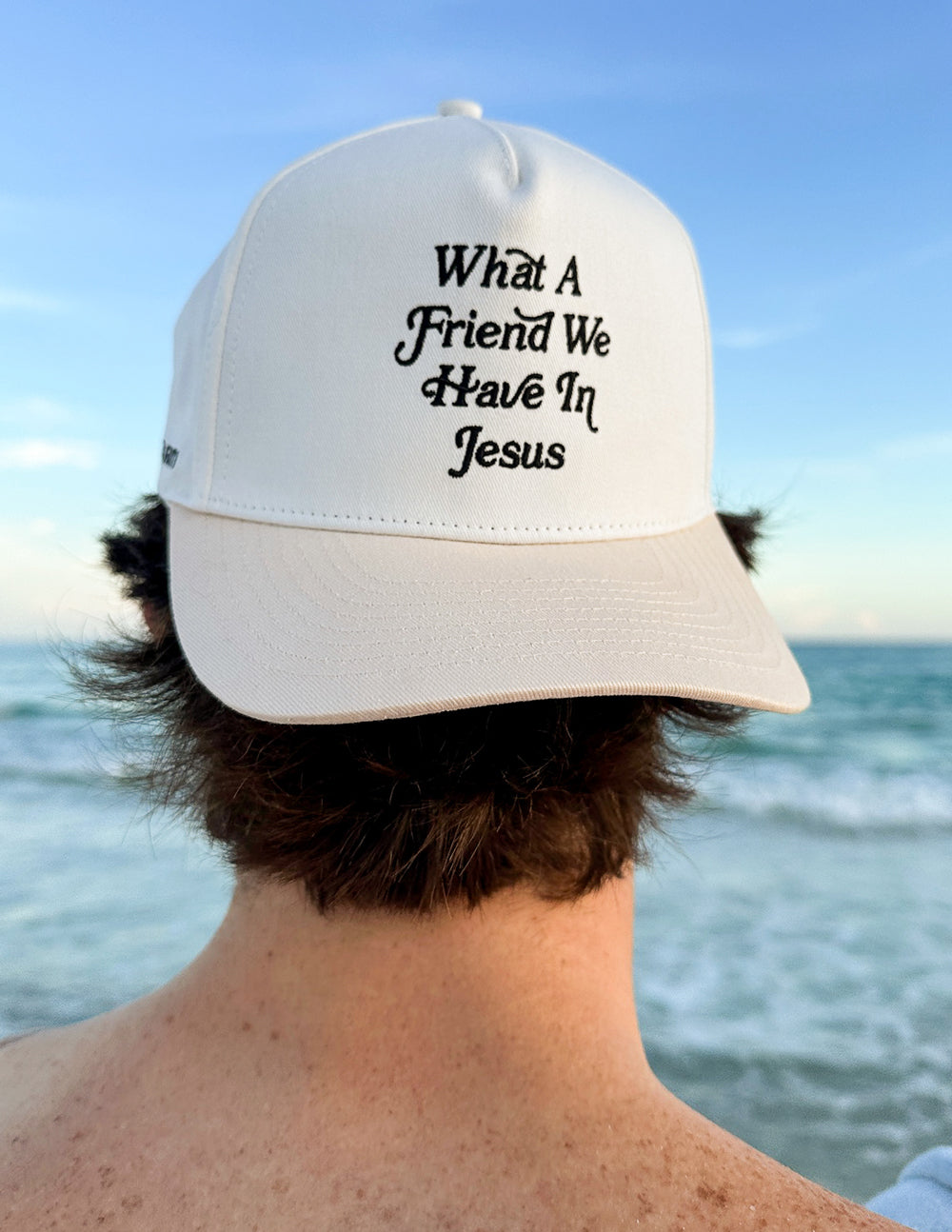 Elevated Faith trucker hat featuring "What a Friend in Jesus" embroidered design on the front, casual adjustable hat for men and women.