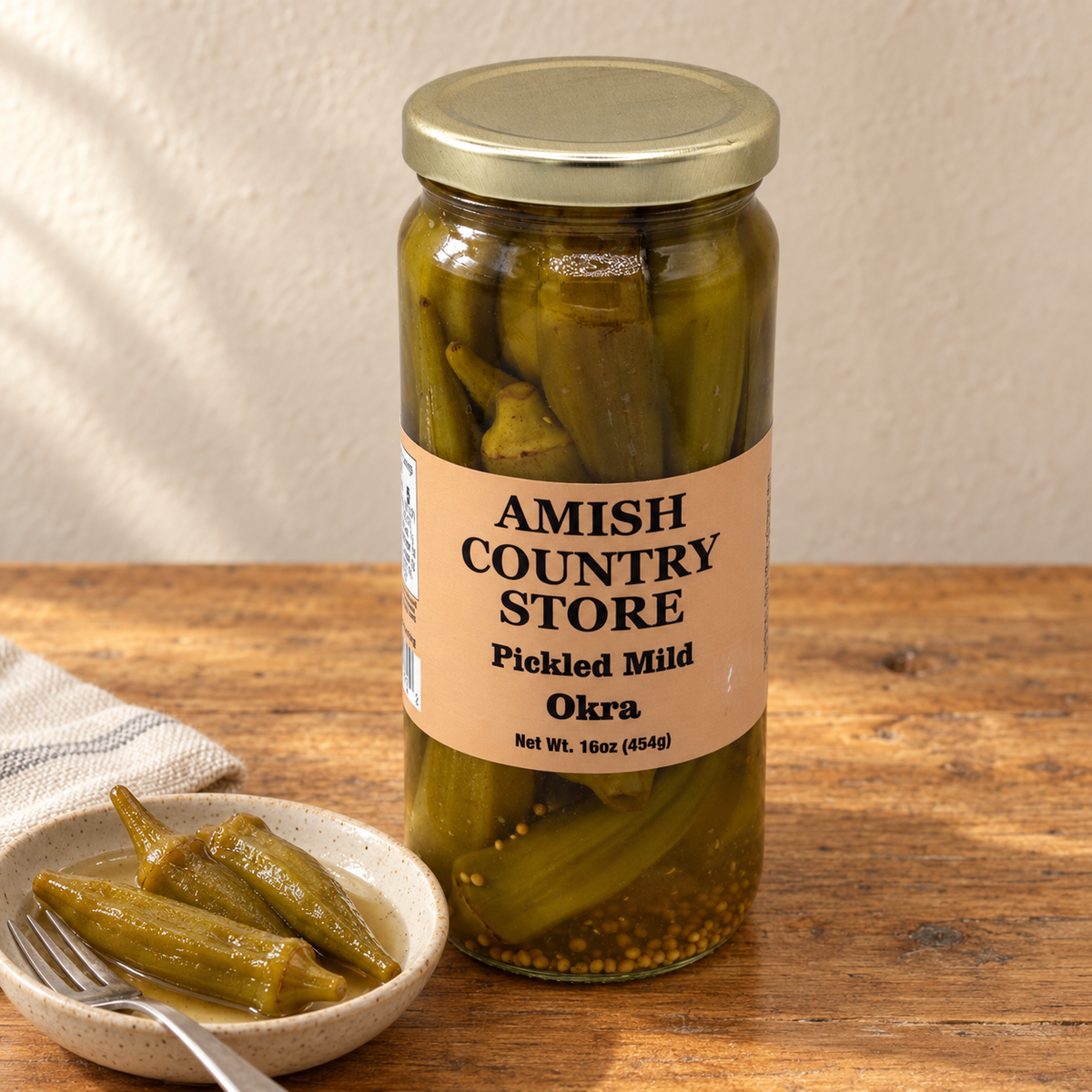 Jar of Amish Country Store pickled mild okra in a clear glass jar with a label, showing the colorful okra inside.