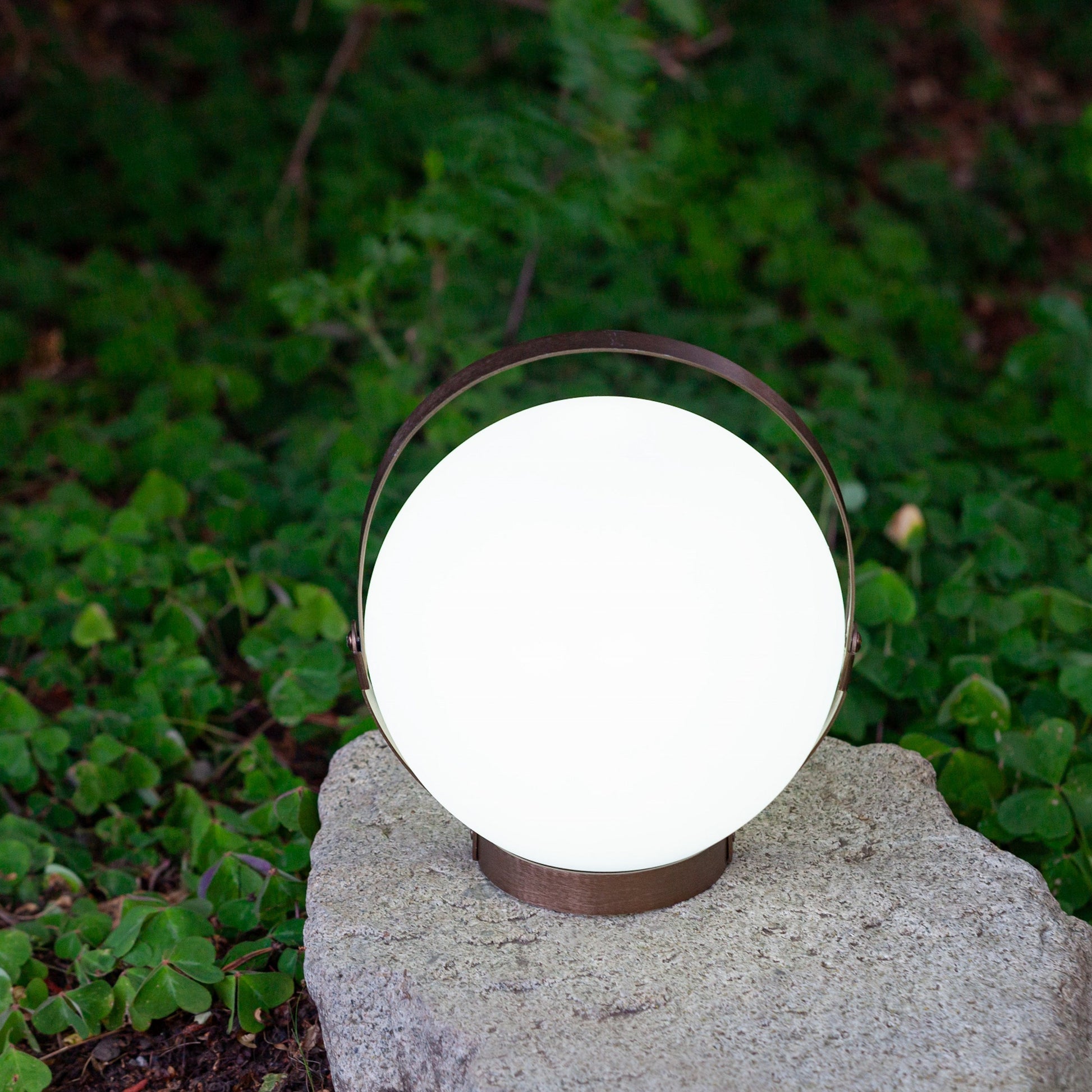 Allsop Home & Garden Moonrise portable rechargeable LED lantern with handle, emitting bright white light for outdoor use.