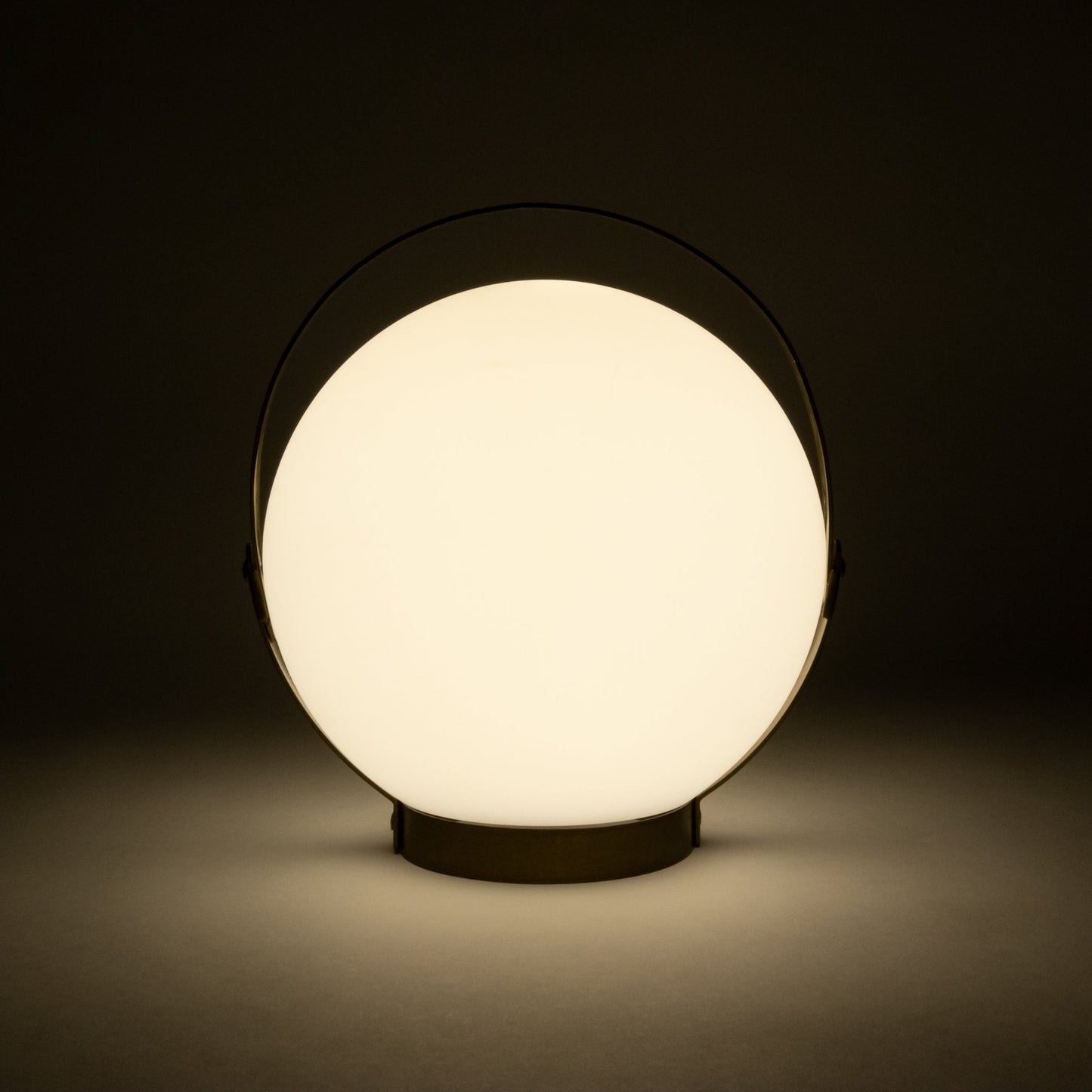 Allsop Home & Garden Moonrise portable rechargeable LED lantern with handle, glowing softly in a dark setting.