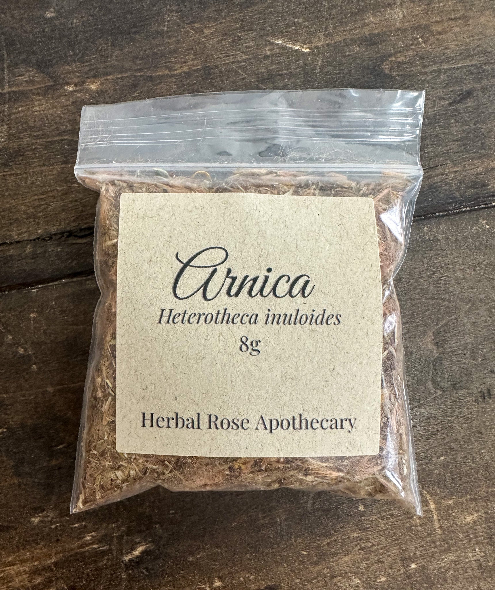Dried Arnica flowers from HerbalRoseApothecary in an 8g package, used as herbal remedy or natural healing herb.