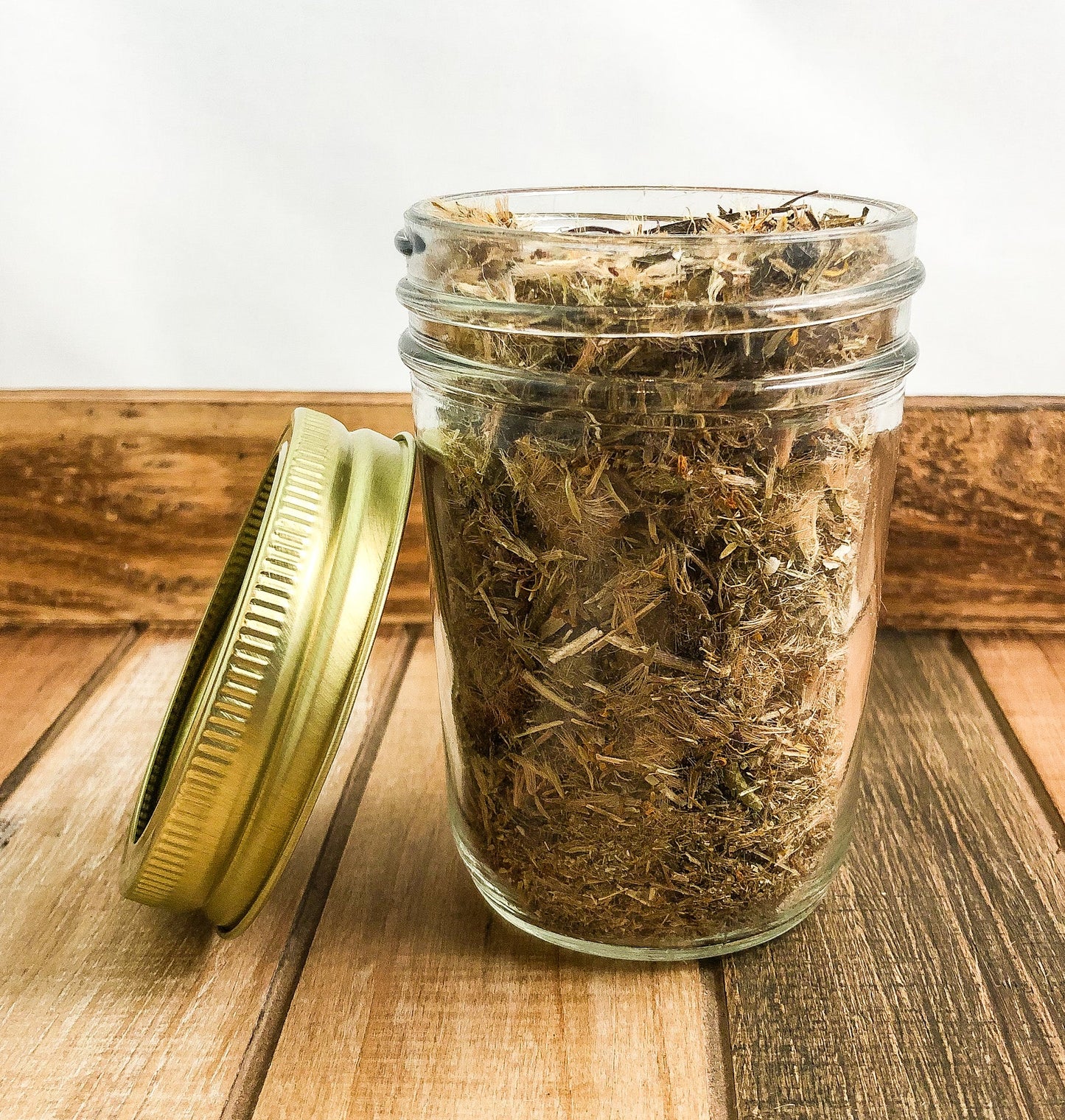 Small jar of dried arnica flowers in herbalroseapothecary herb jars collection, showcasing herbal dried flower herbs.