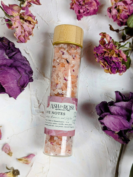 Ash & Rose Love Notes Bath Soak vial with aromatic bath soak, featuring a clear glass vial with a decorative label.