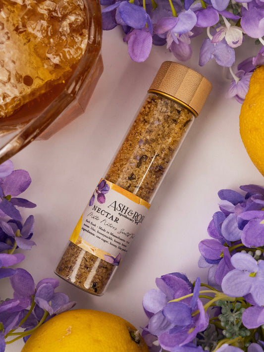 Ash & Rose Nectar Bath Soak vial with natural ingredients, shown in a sleek glass container ready for relaxing bath routines.