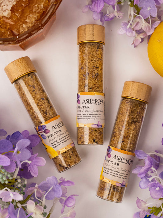 Ash & Rose Nectar Bath Soak vial showing a small glass bottle with a floral label for relaxing bath experiences.