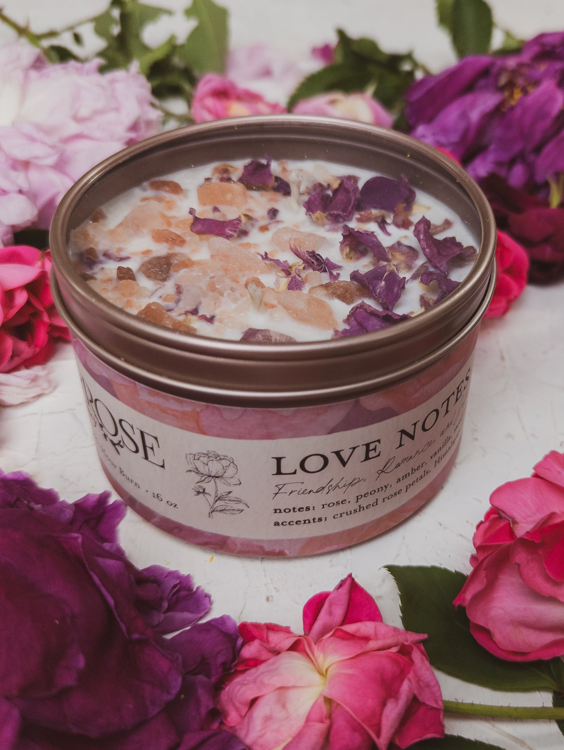 Ash & Rose LOVE NOTES Rose and Pink Salt Candle with a pink-colored wax in a clear glass container.