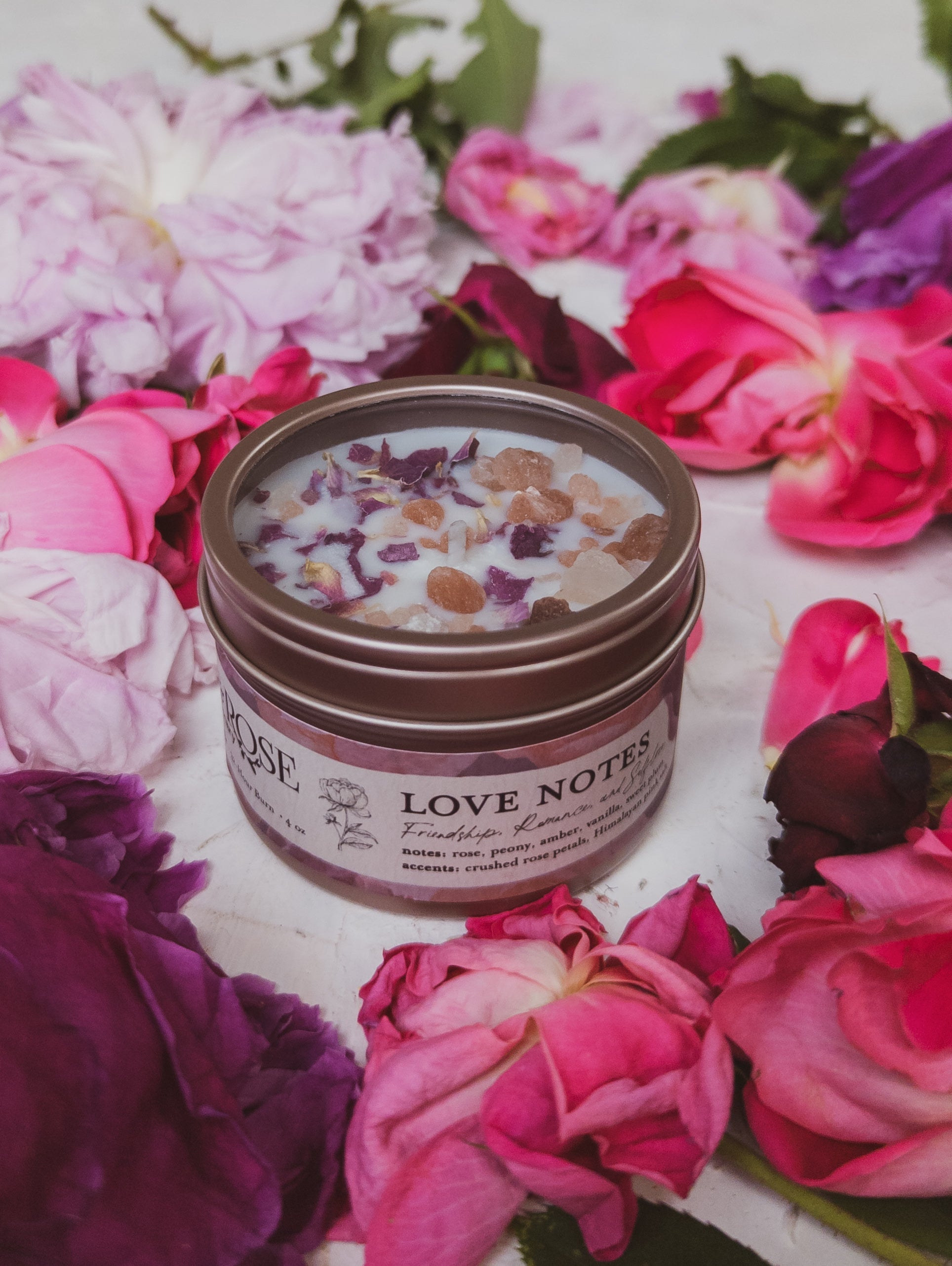 Ash & Rose Love Notes Rose and Pink Salt Candle in a 4 oz glass jar with a white wax candle and floral design.