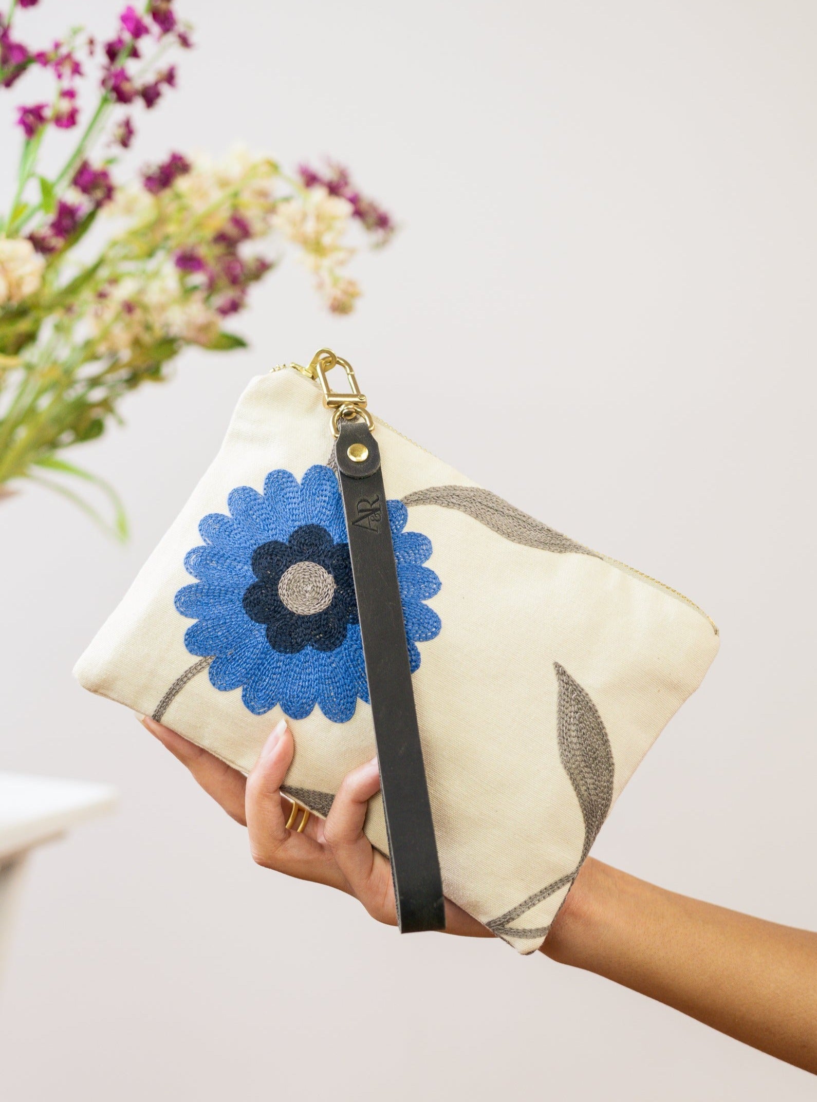Blue Poppy wristlet purse by Ash & Rose featuring a floral pattern with a zipper closure and wrist strap.