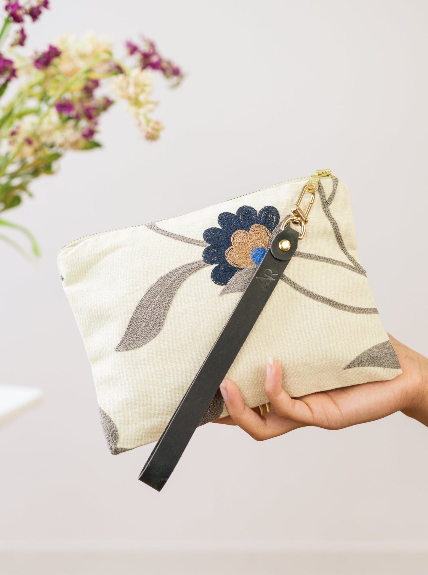 Blue Poppy wristlet purse by Ash & Rose featuring a sleek design and compact size, perfect for carrying essentials.