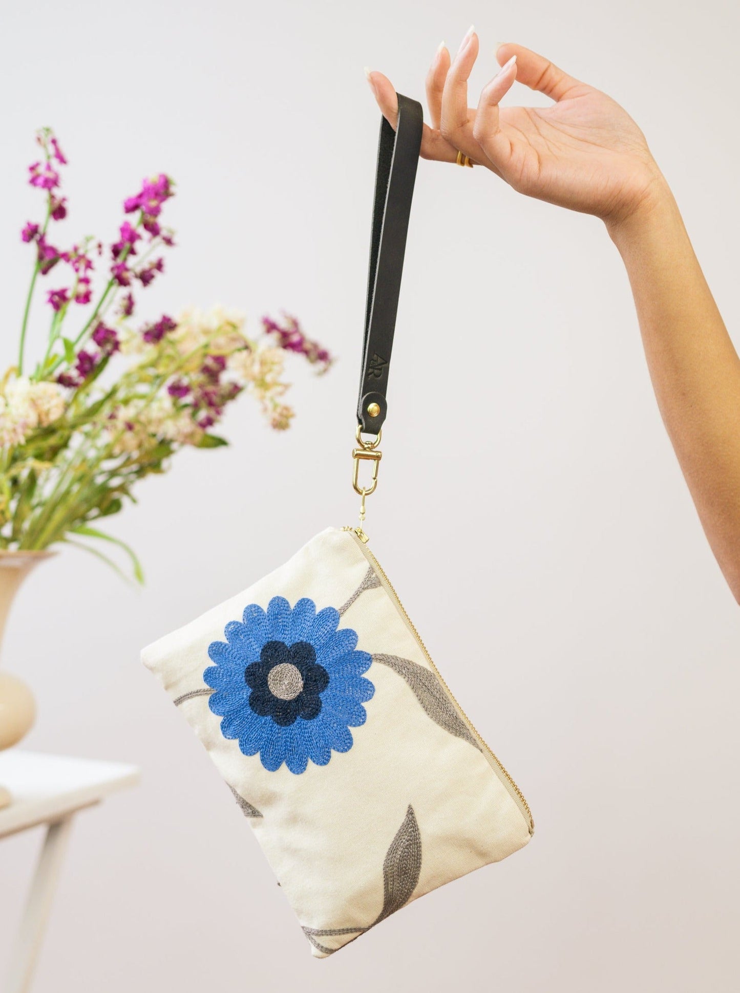 Blue Poppy wristlet purse by Ash & Rose featuring a floral pattern and compact design, ideal for carrying essentials.
