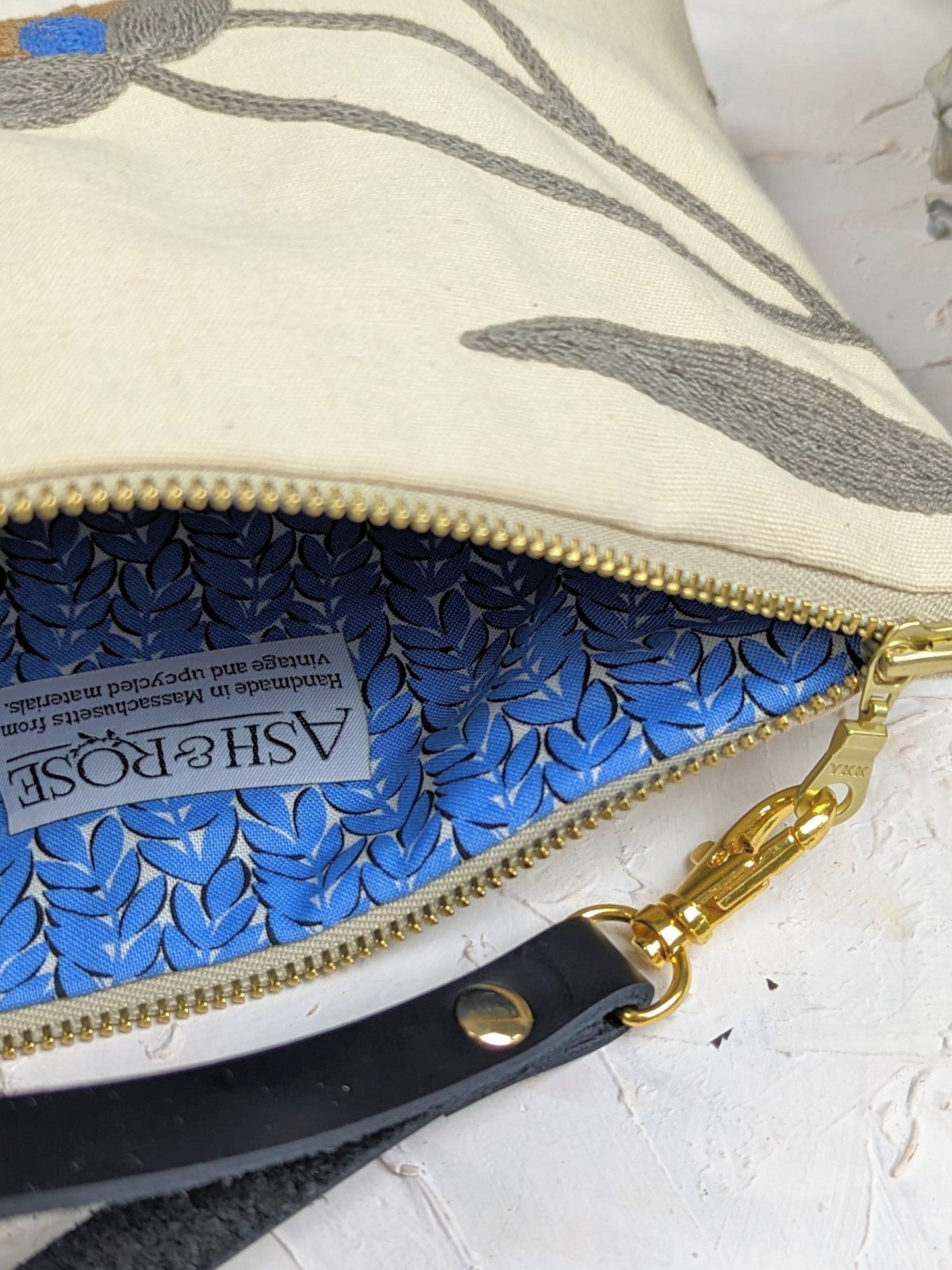 Blue Poppy wristlet purse by Ash & Rose featuring a floral design and compact size, perfect for carrying essentials.