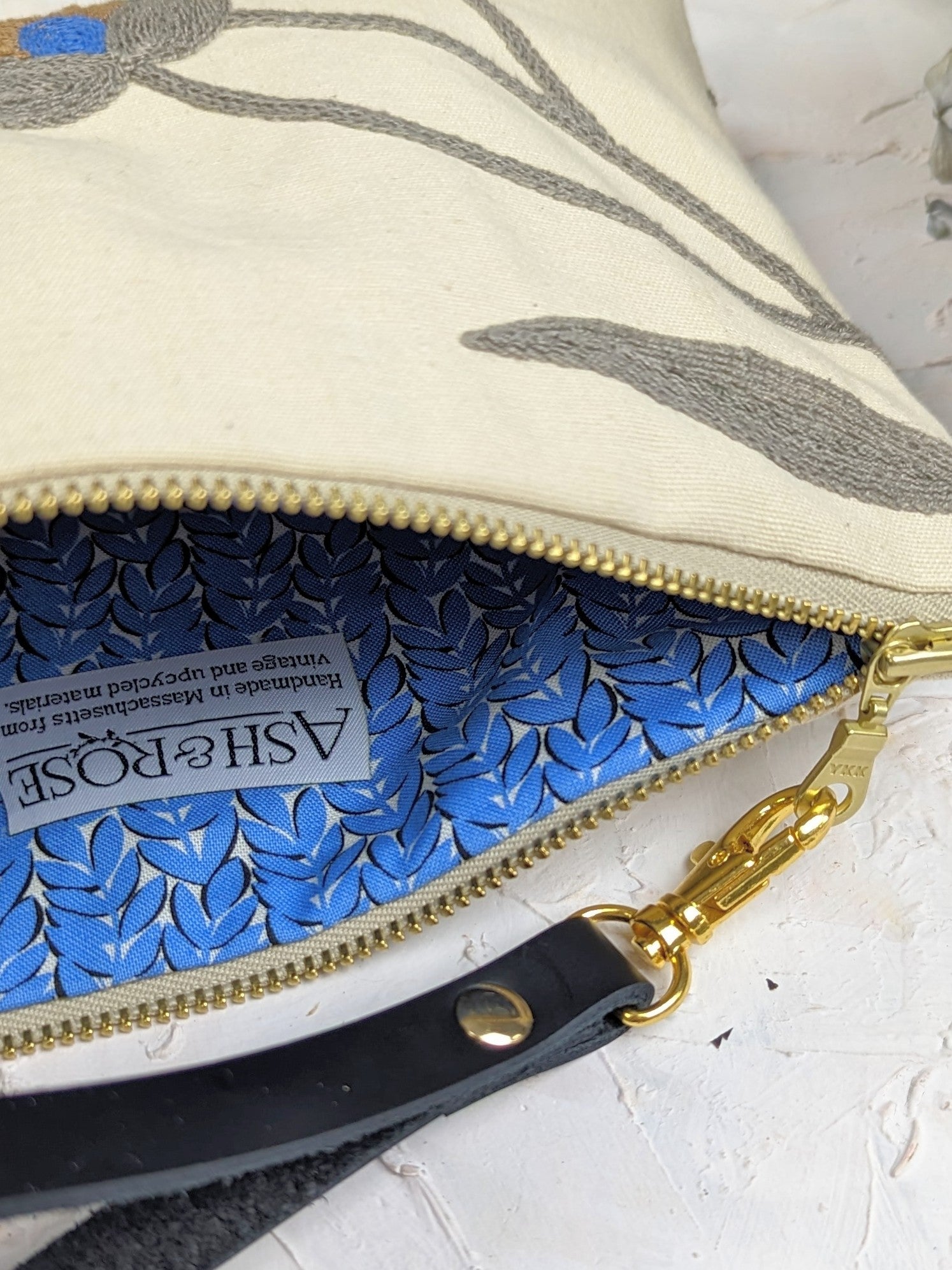 Blue Poppy wristlet purse by Ash & Rose featuring a floral design and compact size, perfect for carrying essentials.