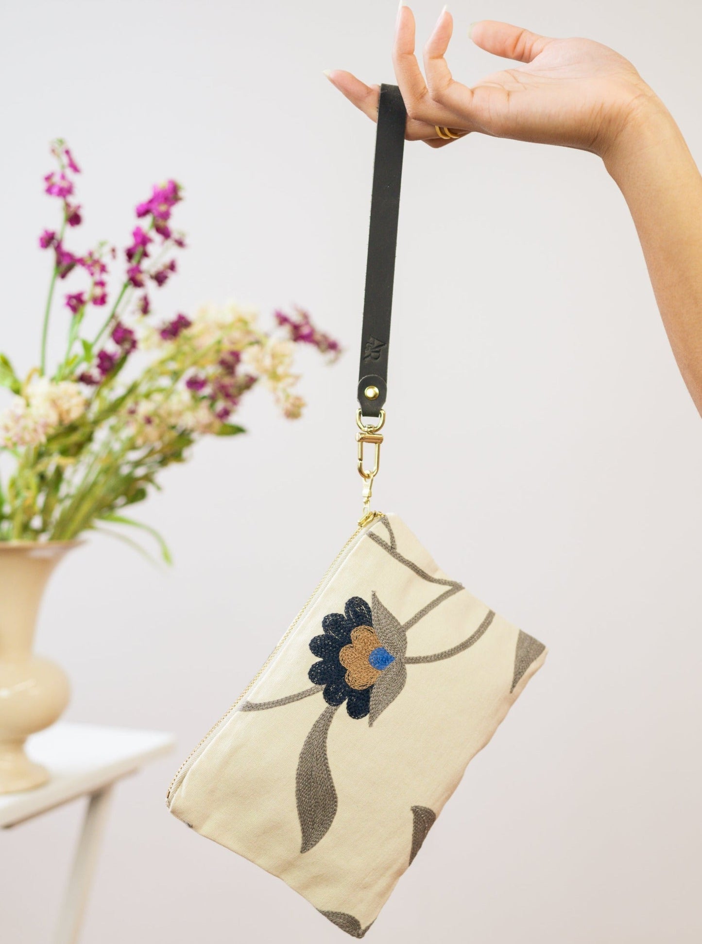 Blue Poppy wristlet purse by Ash & Rose featuring a floral design and compact size for easy carrying and stylish accessorizing.