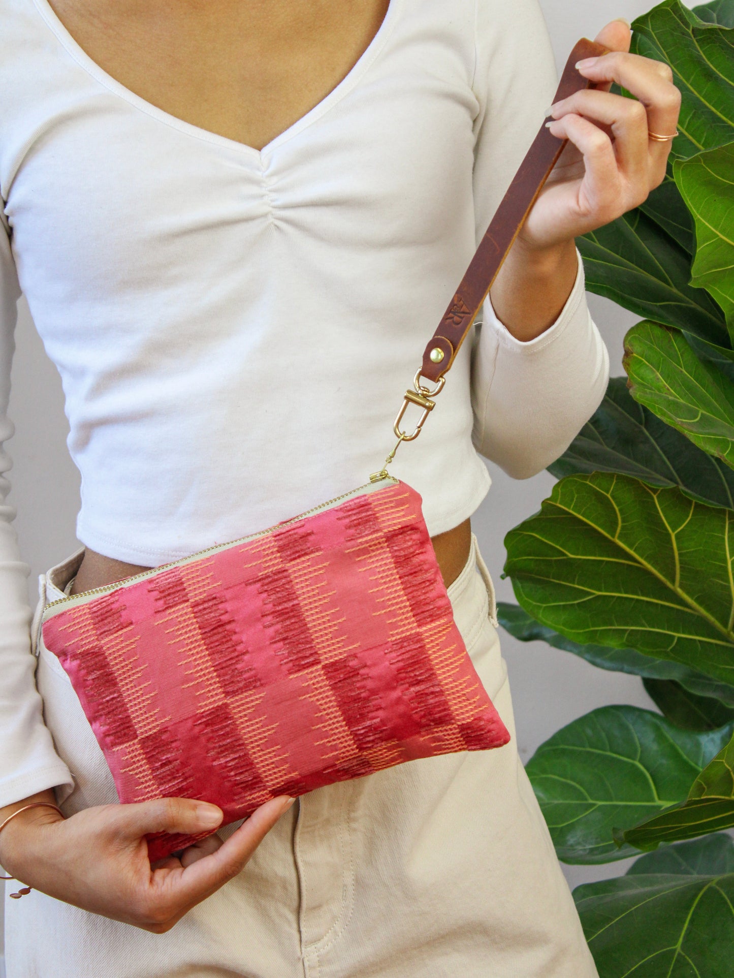 Ash & Rose Shades of Apricot wristlet purse made of soft textured material with a compact design and wrist strap.