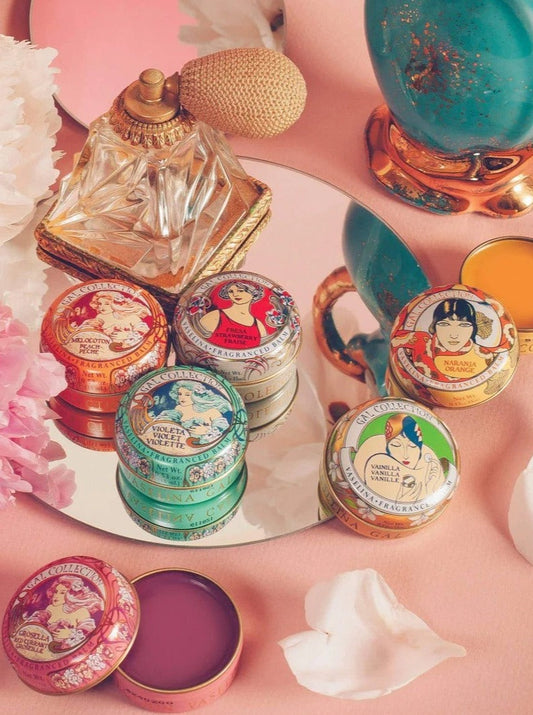 Ash & Rose Perfumeria Gal scented lip balm in orange flavor, featuring a sleek tube and vibrant packaging.