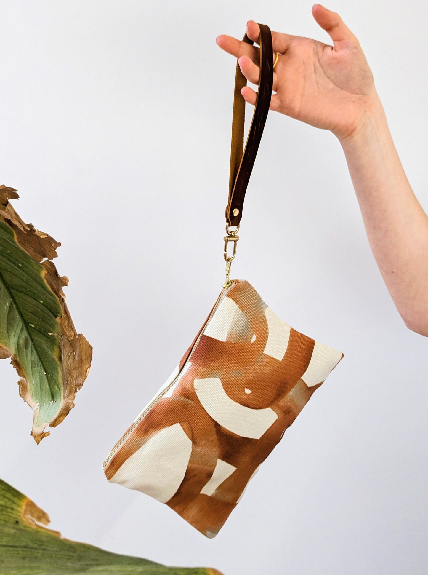 Ash & Rose Shipwreck Chain Wristlet Purse with chain strap and textured exterior, ideal for carrying essentials.