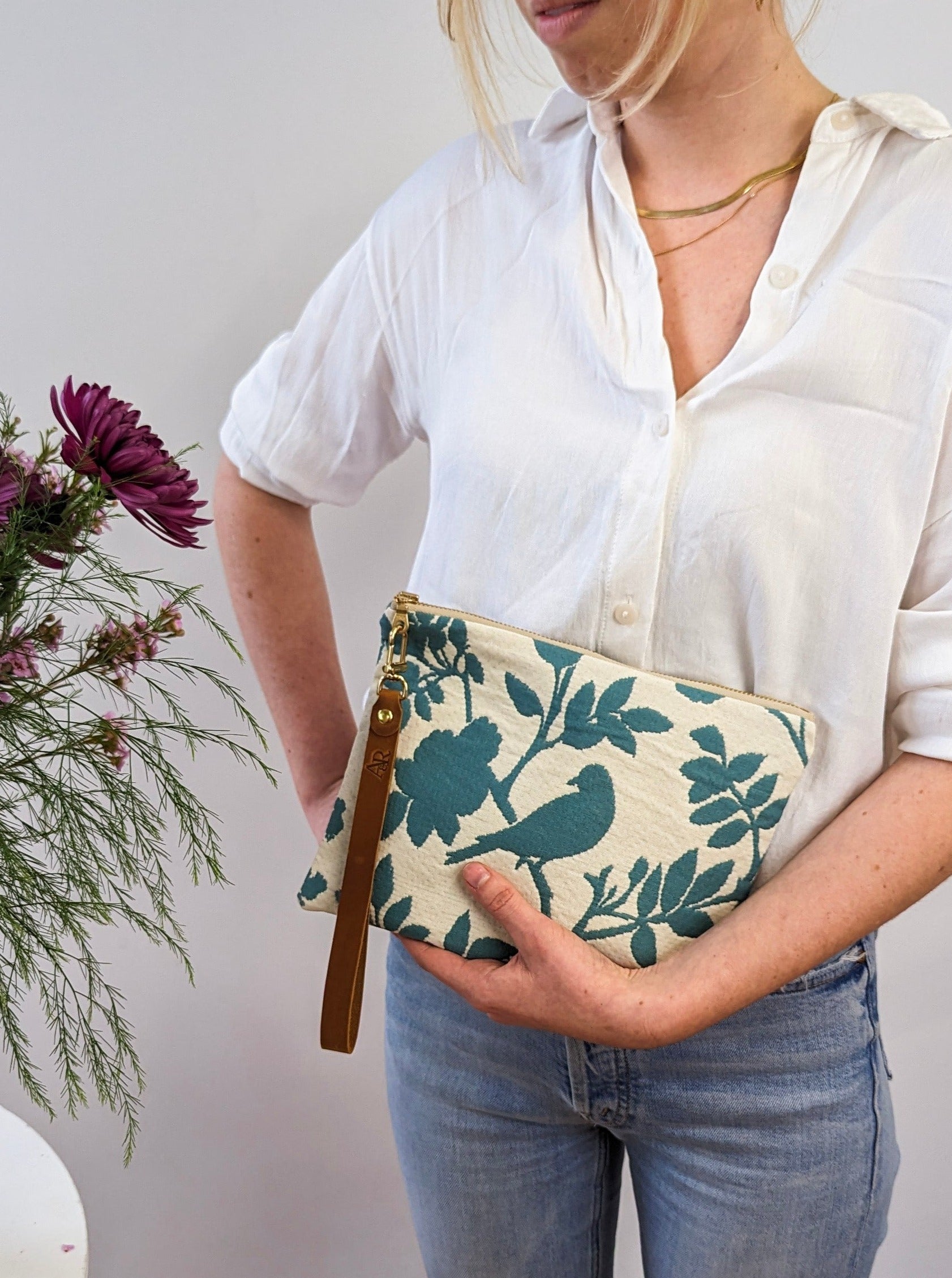Ash & Rose bird silhouette wristlet purse featuring a compact design with a wrist strap and decorative bird pattern.
