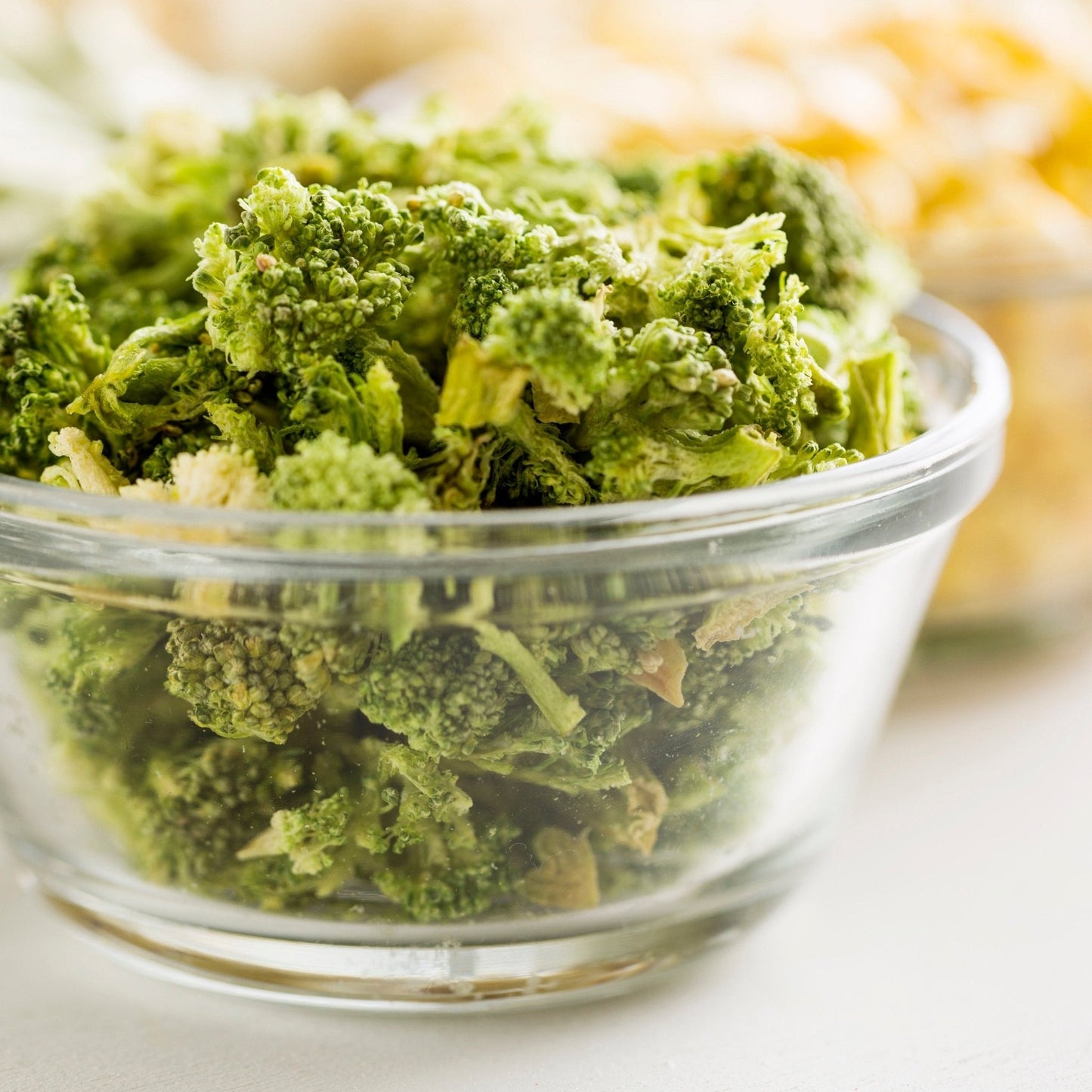 Can of Augason Farms freeze-dried broccoli florets and stems, 34 servings, showing dried green broccoli pieces inside the can.